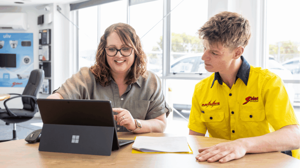 Apprentice meeting with training advisor reviewing work on laptop in New Zealand